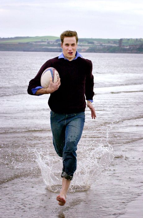 Prince William running on the beach with a rugby ball