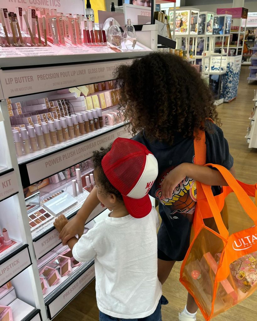 Two kids looking at a Kylie Cosmetics stand in the supermarket