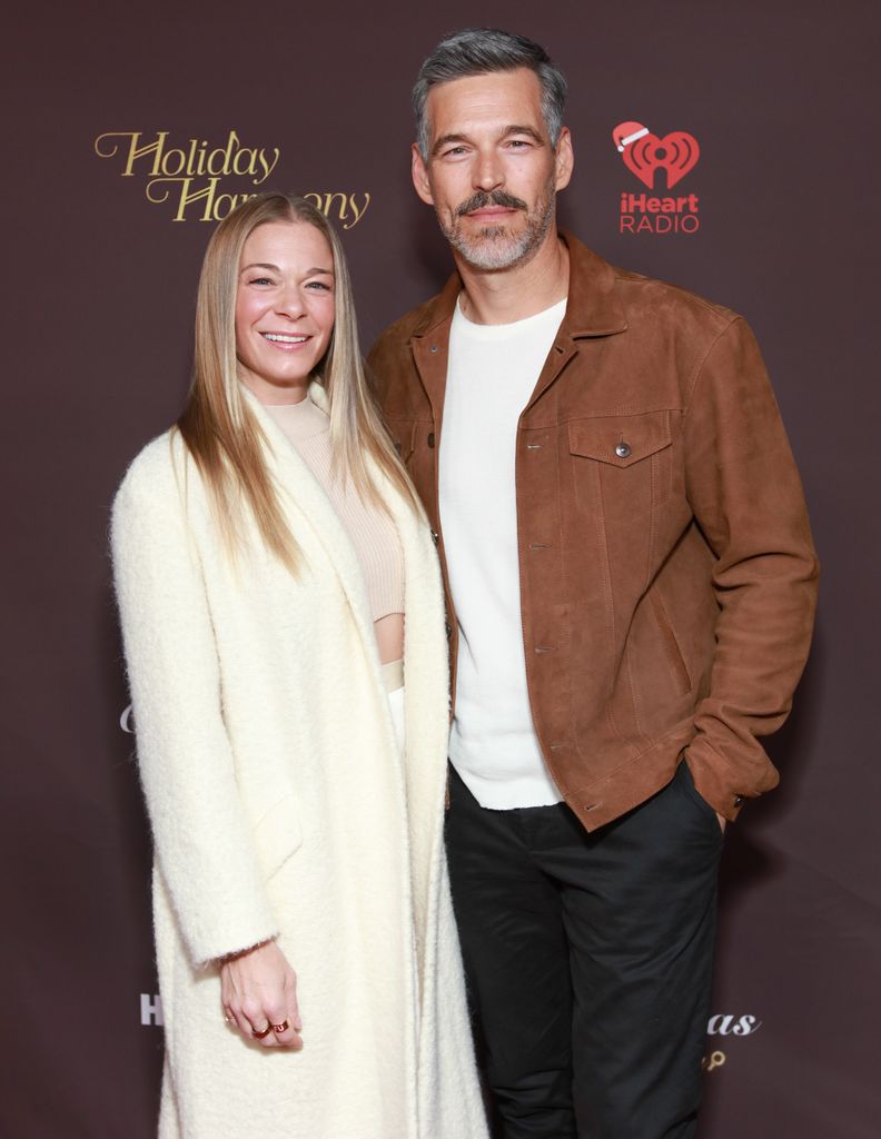 LeAnn RImes in a cream dress with Eddie Cibrian in a brown jacket and black trousers