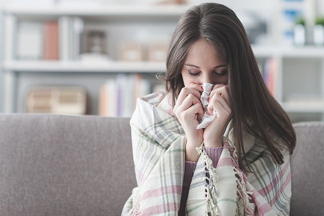 woman blowing nose cold