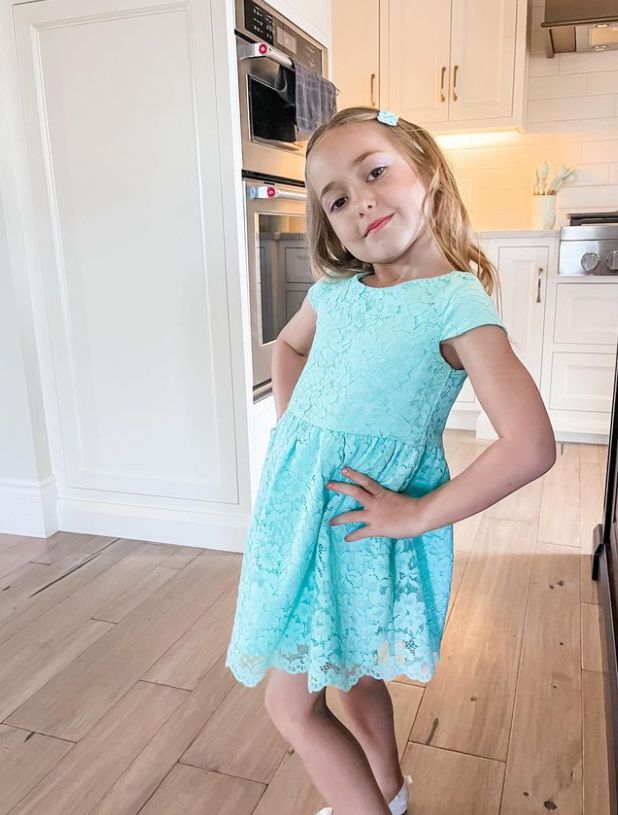 Bay Bieber posing in a kitchen wearing a blue dress