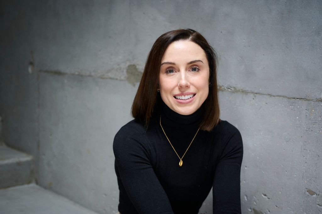 Smiling brunette woman wearing black polo shirt