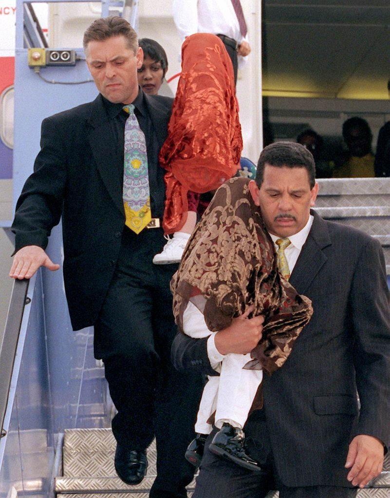 Wrapped in blankets, the two children of US pop star Michael Jackson, Prince Michael Jr. and Paris Michael Katherine, are carried off the plane at Munich Airport on June 26, 1999.