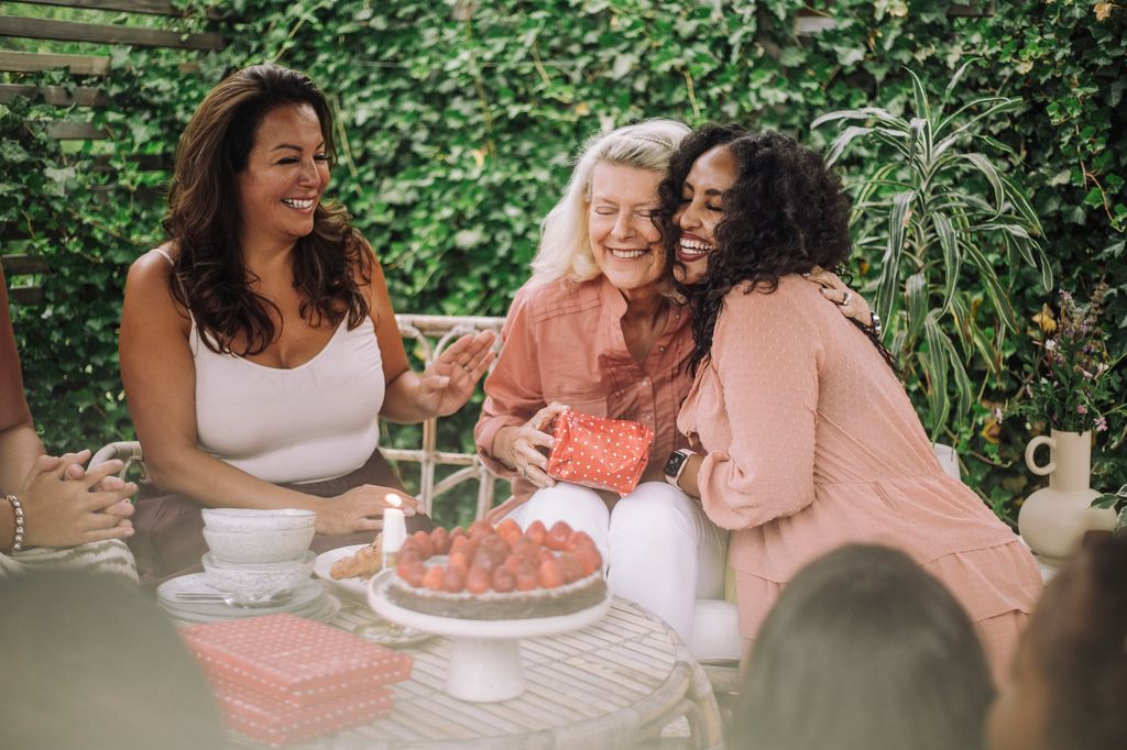 Smiling daughter embracing mother in birthday party