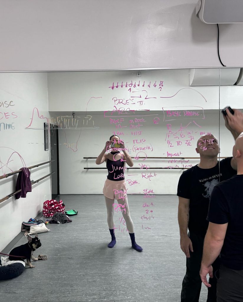 Brie taking mirror photo in dance studio with teacher