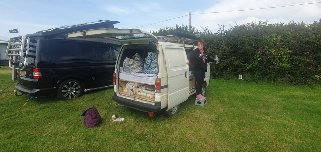 Woman standing on the outside of a camper van