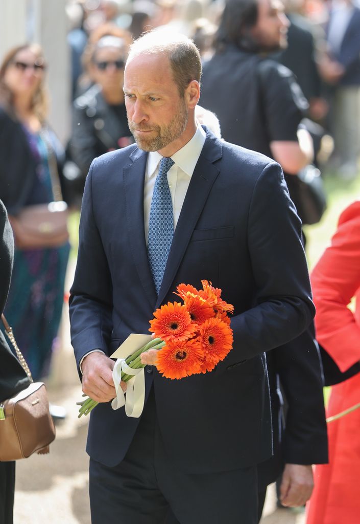  Prince William, Prince of Wales holds a bouquet of flowers as he attends a memorial service for the 20th Anniversary of the 7th of July 2005 bombings at Memorial Gardens at Hyde Park 