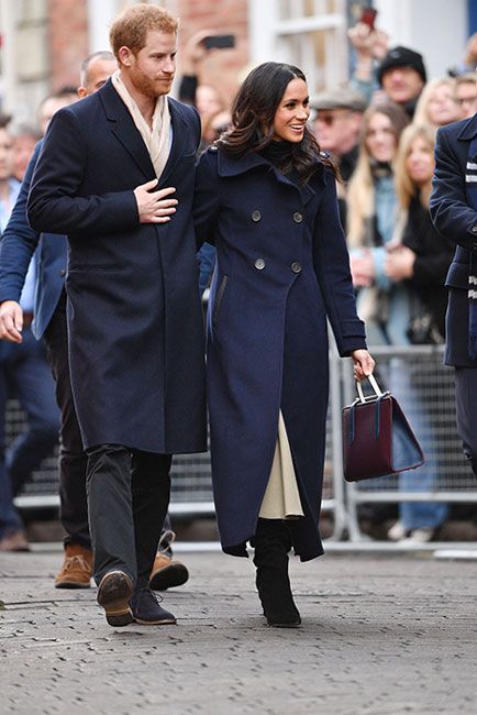 harry and meghan wear similar double breasted navy coats as they walk past crowds outside during the day