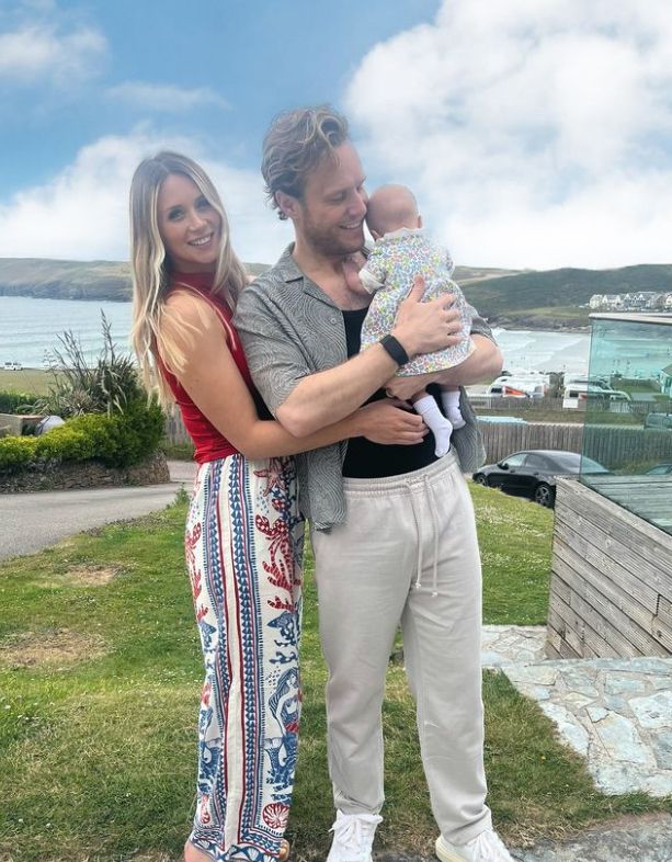 Amelia Tank embracing Olly Murs who is holding a baby girl