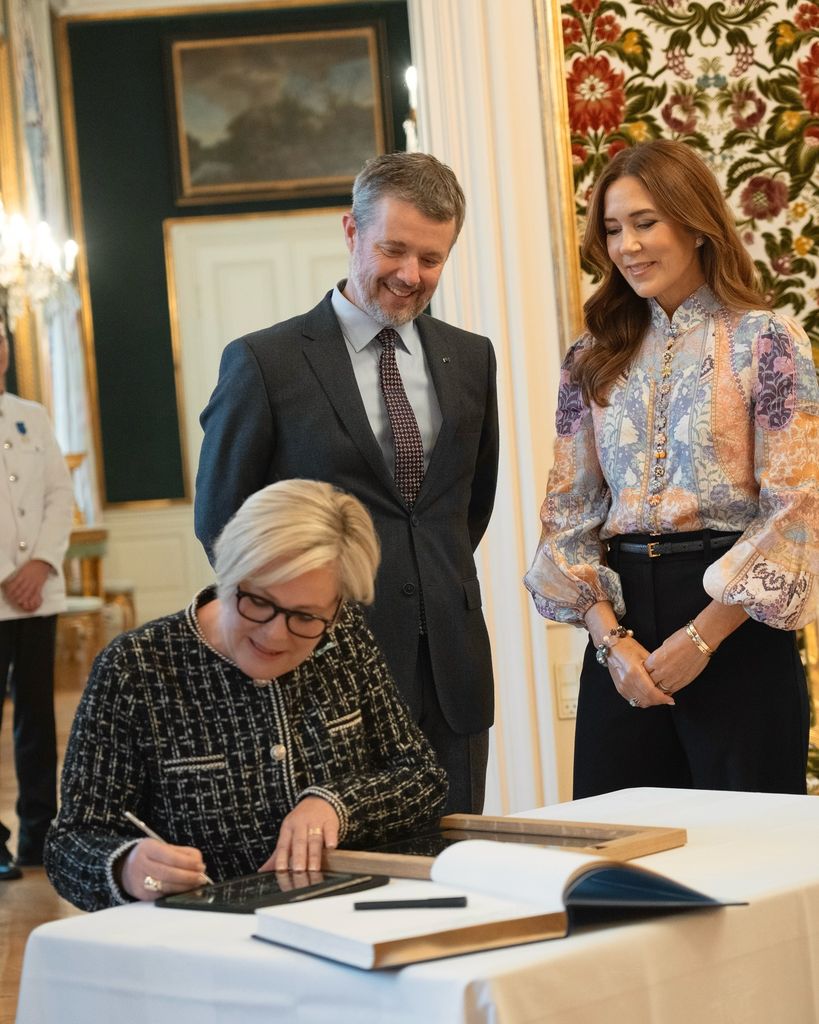 Królowa Maria patrzy na islandzkiego prezydenta podpisującego szybę