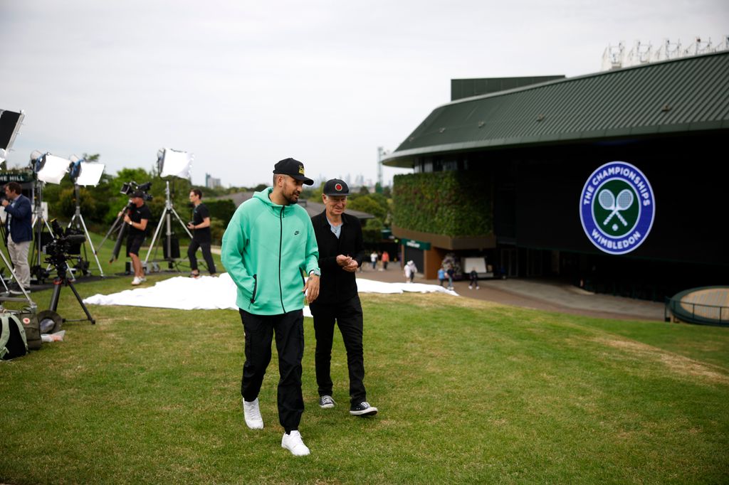 John McEnroe walks with Nick Kyrgios