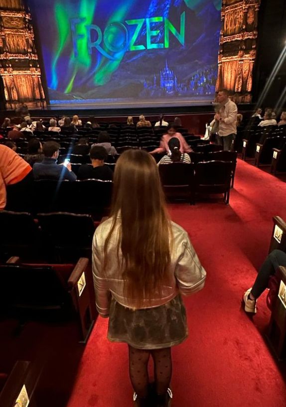 A young girl in a half-filled theatre