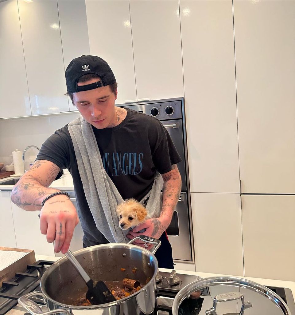Brooklyn shared a photo of himself cooking alongside a sweet puppy