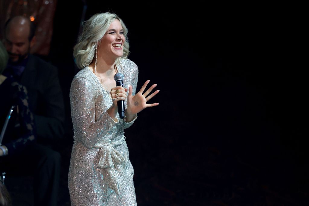 Joss Stone sparkles in shimmering silver dress as she holds microphone