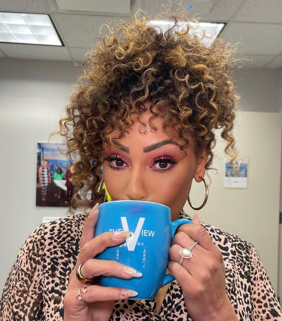 Scary Spice wearing her engagement ring while sipping from a mug