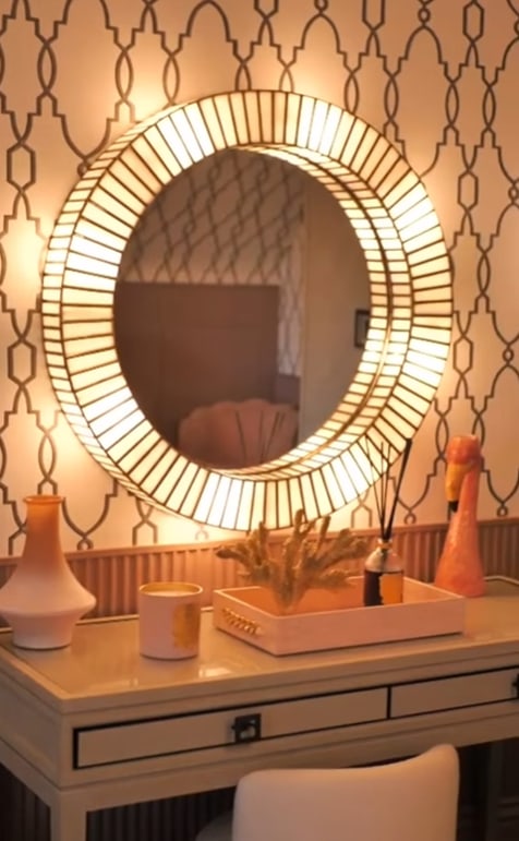 Dressing table with circular, light-up mirror on the wall