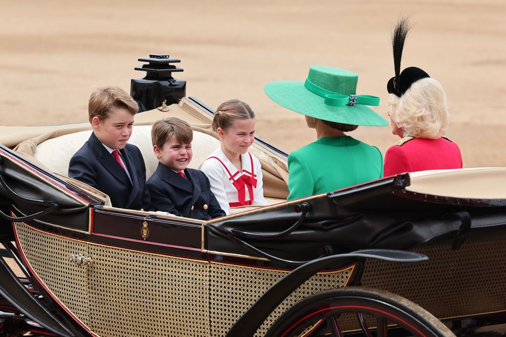 Prince George, Princess Charlotte and Prince Louis ride in a horse-drawn carriage with Princess Kate and Queen Camilla at Trooping the Colour