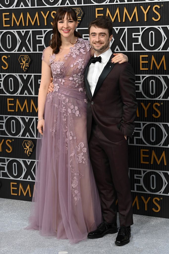  Daniel Radcliffe in black tux and Erin Darke in one shoulder purple tulle gown at 75th Primetime Emmy Awards