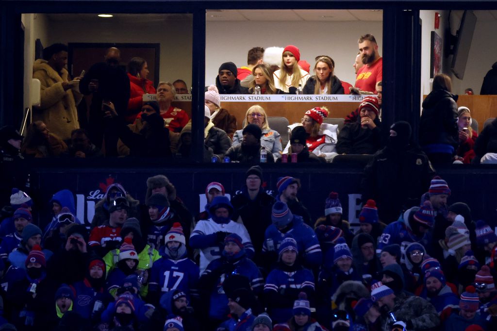 Singer-songwriter Taylor Swift (red hat C) sits with Jason Kelsey (right) and Kylie Kelsey (right) 