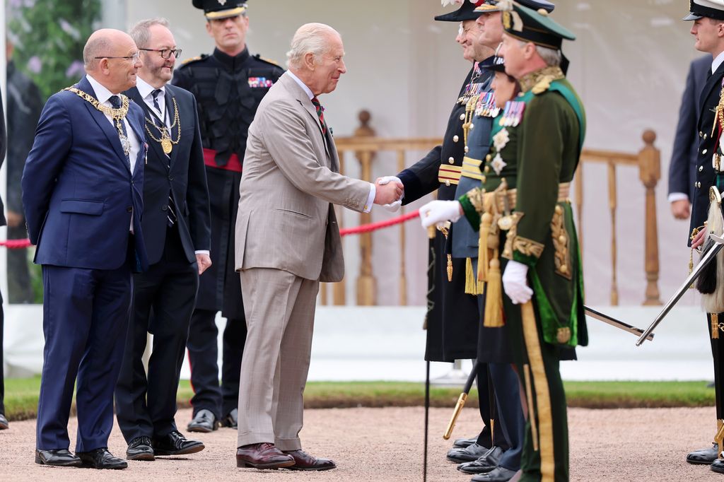 king charles shaking hands with someone 