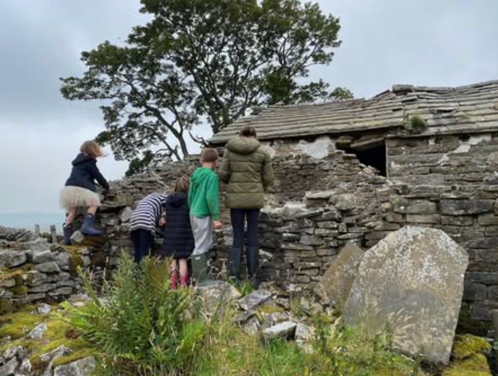 children outside of cottage ruin