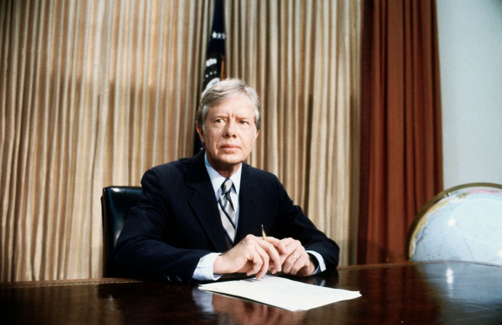 President Jimmy Carter, seated at desk in Oval Office of White House 