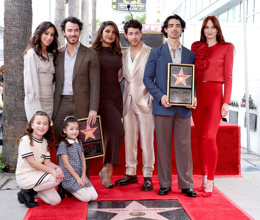 the jonas brothers with their wives at hollywood walk of fame