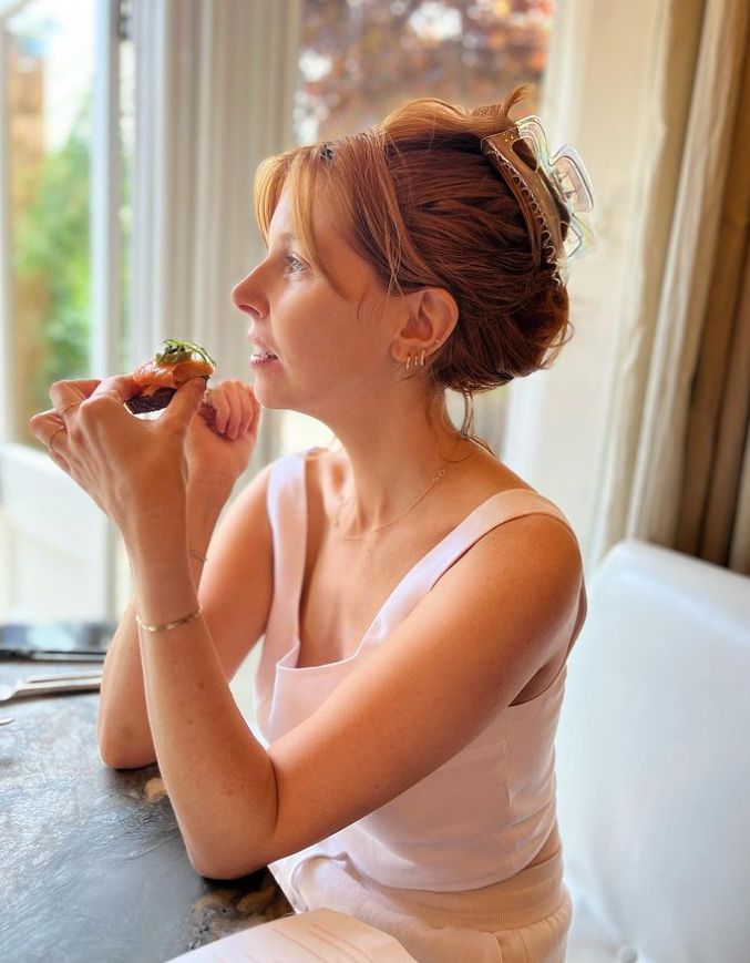 Stacey Dooley holding a salmon hors d'oeuvre.