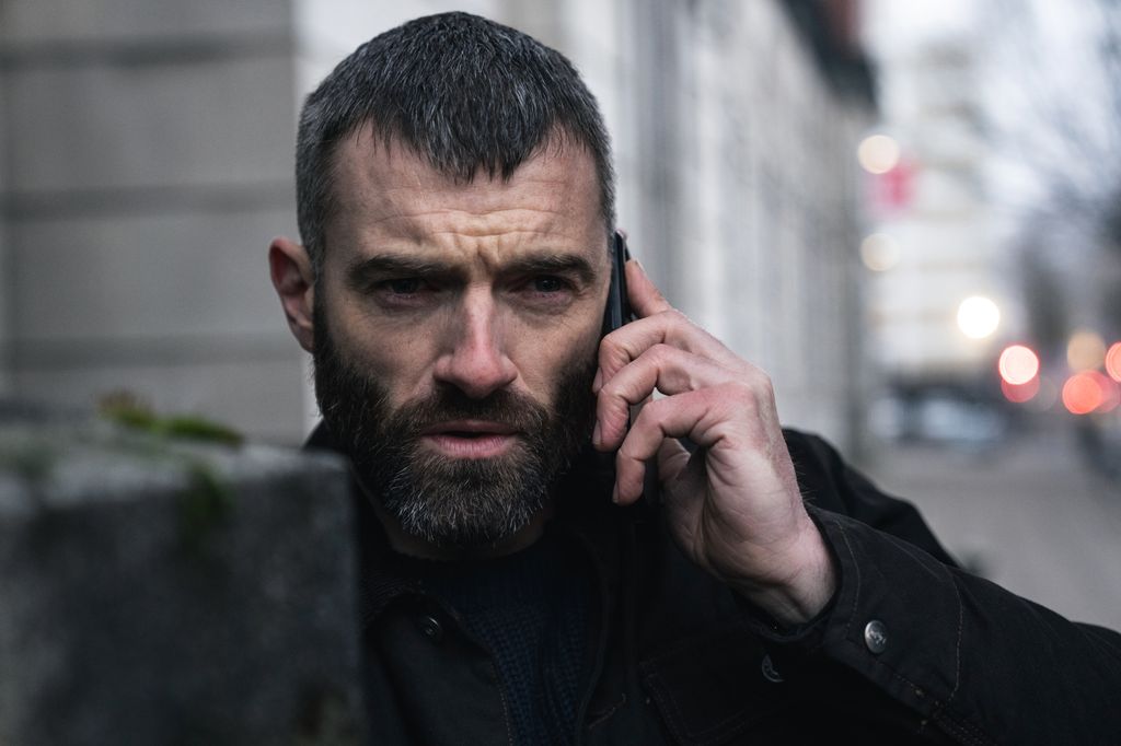 close-up of man holding phone in street