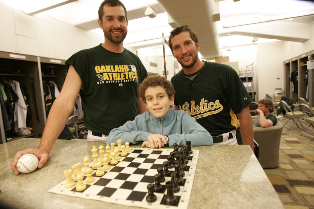 Chess champion Daniel Naroditsky meets Andrew Brown and Huston Street of the Oakland Athletics in the clubhouse before the game against the Minnesota Twins at McAfee Coliseum in Oakland, California on April 23, 2008