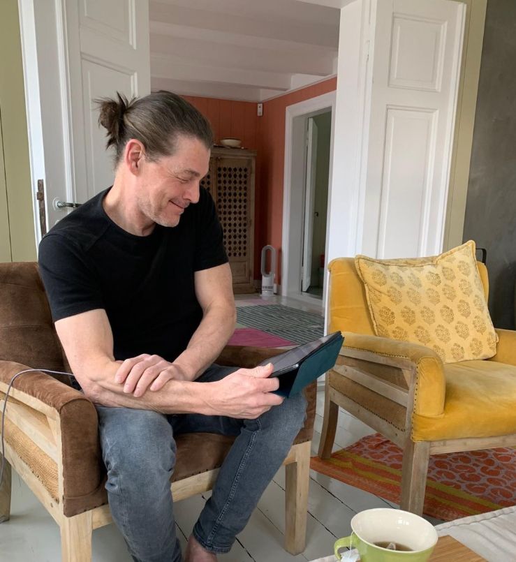 Morton Harket with an iPad sitting inside a living room