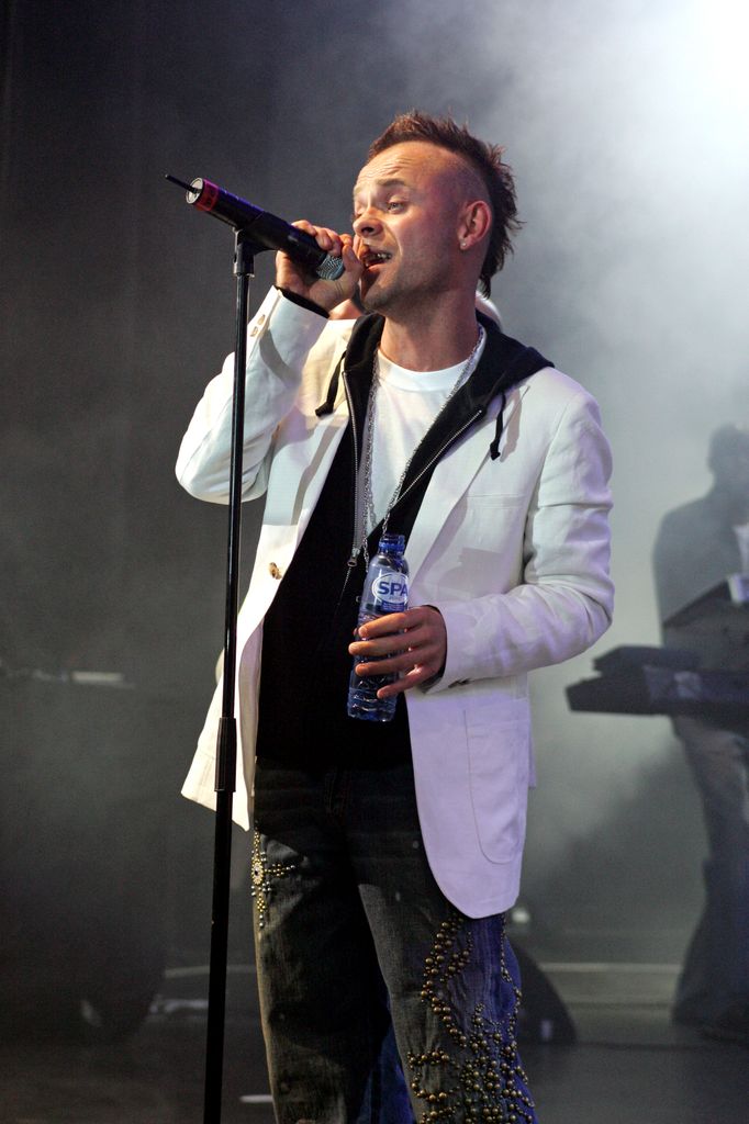 Brian Harvey performing in a white jacket and jeans