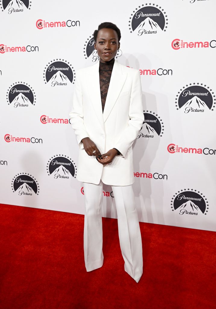 Lupita  in a white suit on red carpet