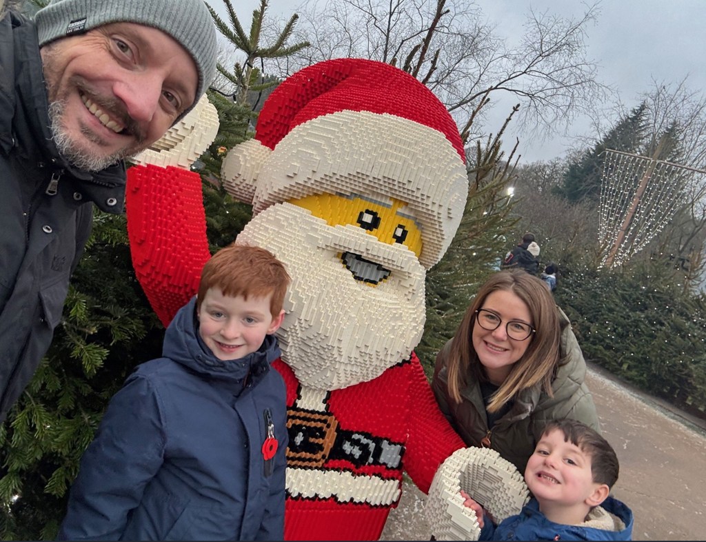 Lauren with husband and sons with lego santa