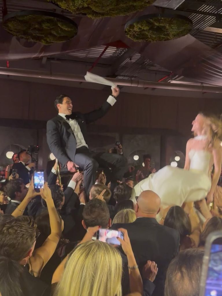 Will and his new wife on their wedding day hoisted in air on chairs