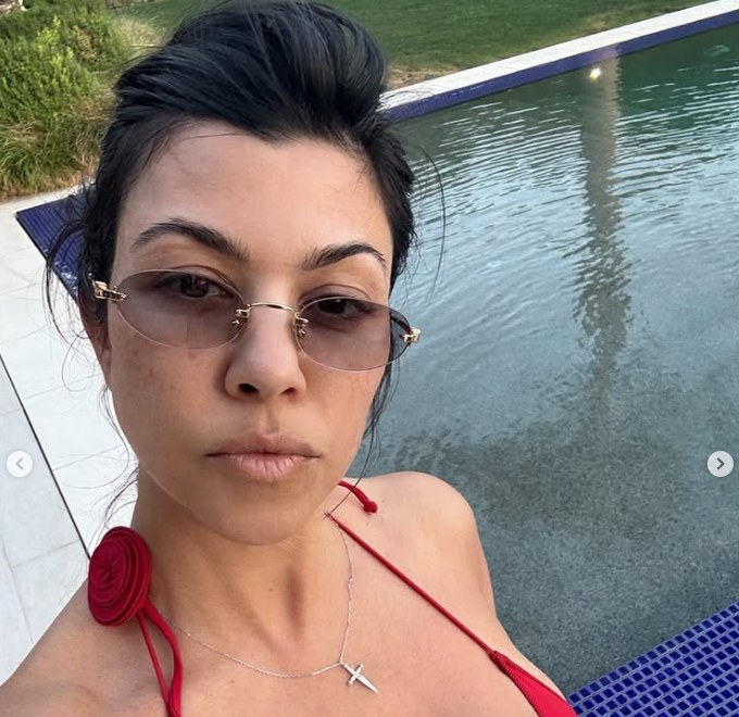 Kourtney Kardashian taking a selfie in front of her pool at Palm Springs home