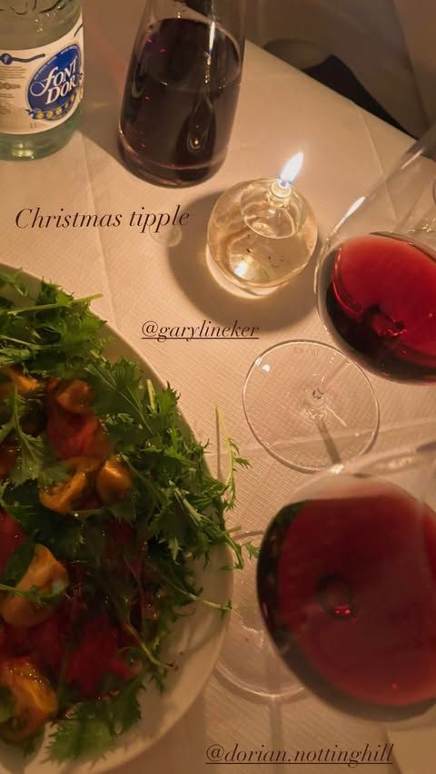 candle-lit table with bowl of salad and glasses of wine