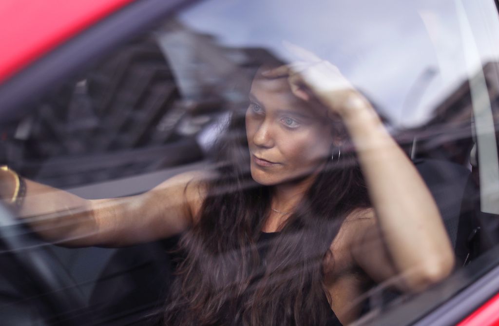 Woman stressed and anxious behind wheel of red car