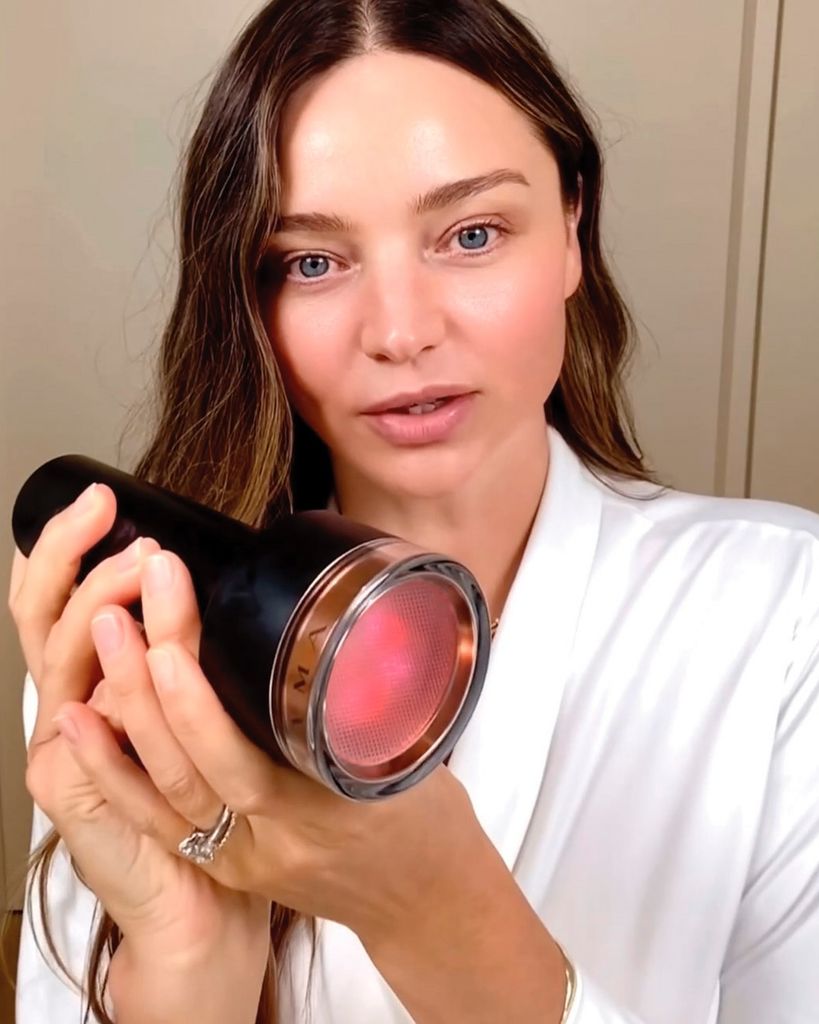 Miranda Kerr holding Lyma Laser Pro towards camera