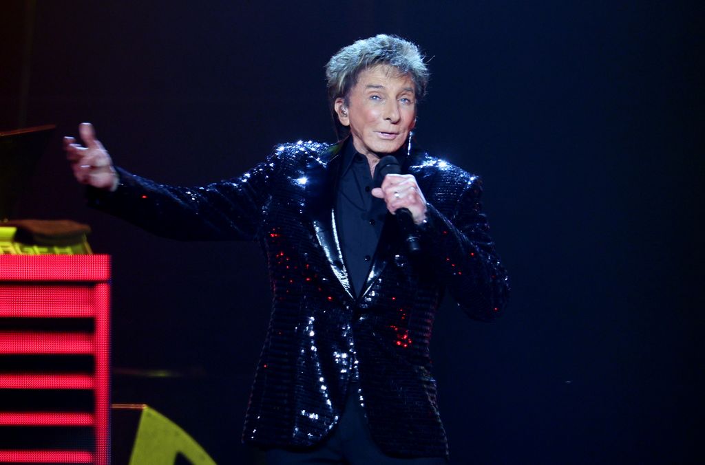 Barry Manilow partage une mise à jour pleine d'espoir sur sa santé suite à la peur du cancer : "J'ai réussi" 2 photo de Barry Manilow tenant un micro sur scène