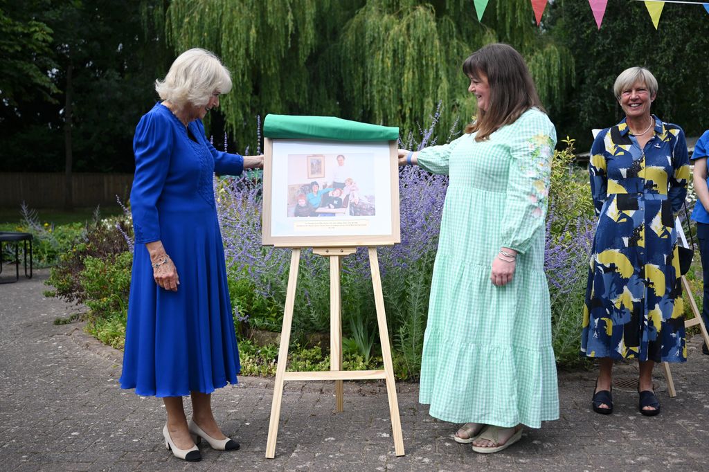 Queen Camilla unveils a commemorative photograph as she joins staff, volunteers and families in celebrating the hospice's 30th anniversary at CHSW Little Bridge House 