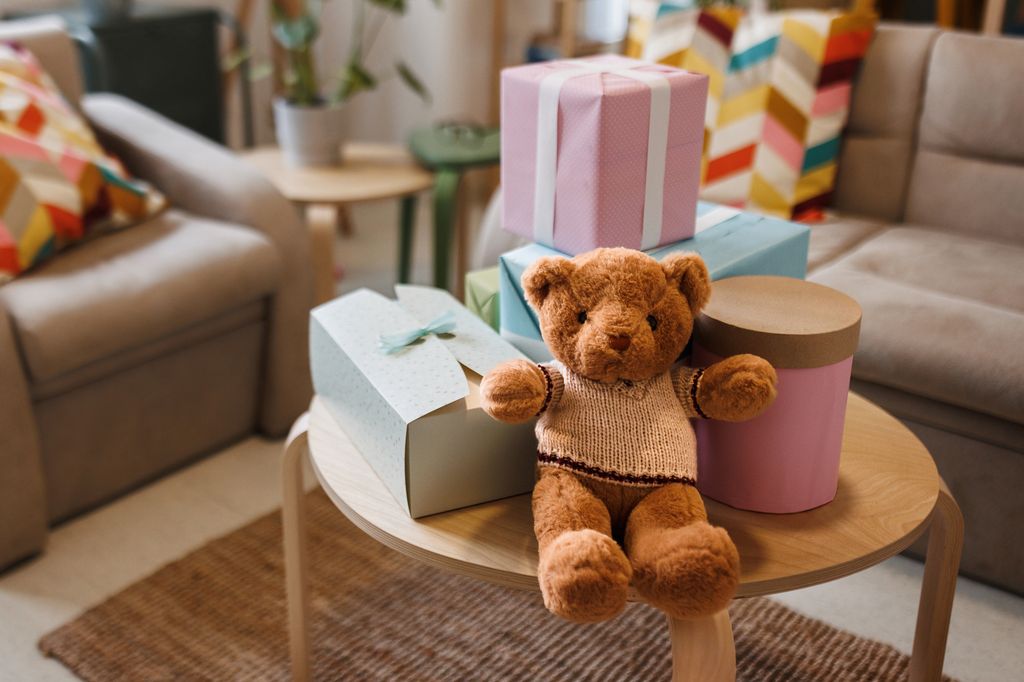 Baby shower gifts on table with teddy bear