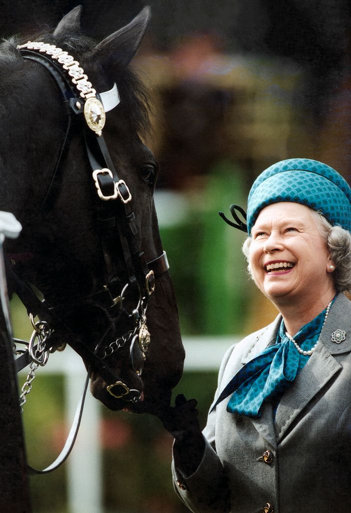 Rainha Elizabeth sorrindo olhando para o cavalo