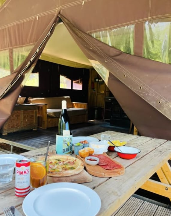 dinner on wooden bench outside luxury tent