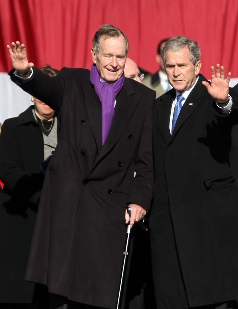 Former presidents George H.W. Bush and George W. Bush wave at the commissioning ceremony for the Navy's newest aircraft carrier the George H.W. Bush (CVN 77), named after the President's father the former President, at Naval Station Norfolk on January 10,