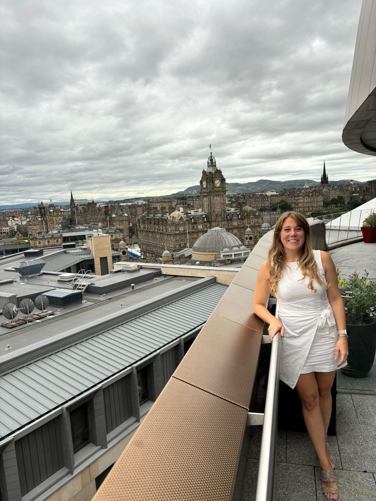 Woman in a white dress on a rooftop bar in Edinburgh