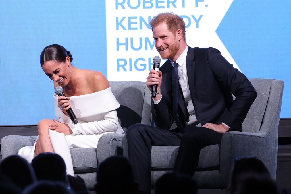 Meghan Markle and Prince Harry sitting together and laughing
