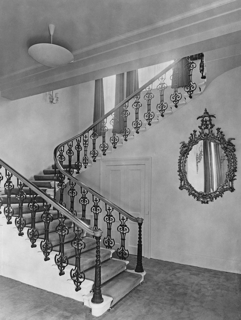 A staircase with a mirror hanging on the wall
