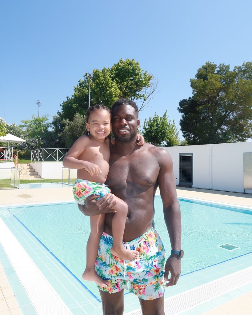 Marcel holding son by pool