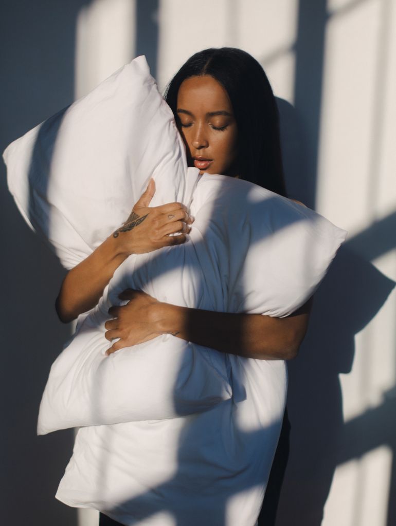 woman hugging a big white fluffy pillow 